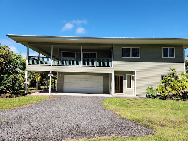 15-974 Lemiwai Rd, Keaau, HI 96749 - view of front of house featuring a balcony, gravel driveway, an attached garage, and a front yard