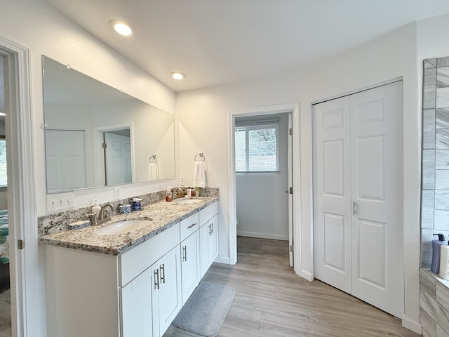 92-8858 Paradise Pkwy, Ocean View, HI 96737 - bathroom featuring double vanity, a closet, wood finished floors, recessed lighting, and baseboards