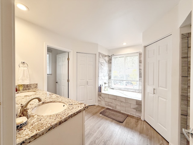 92-8858 Paradise Pkwy, Ocean View, HI 96737 - bathroom featuring a closet, tiled bath, double vanity, wood finished floors, and recessed lighting
