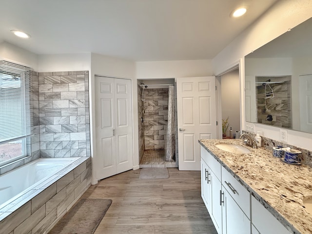 92-8858 Paradise Pkwy, Ocean View, HI 96737 - full bathroom featuring vanity, a bath, tiled shower, wood finished floors, and recessed lighting