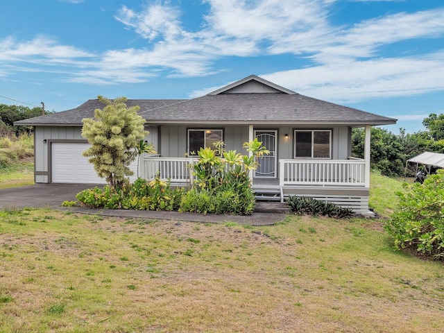 94-1727 Kaulua St, Naalehu, HI 96772 - view of front of home with an attached garage, a porch, asphalt driveway, and board and batten siding