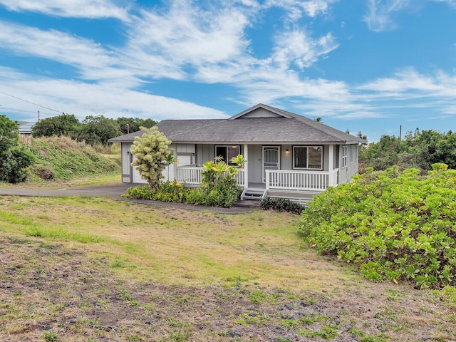 94-1727 Kaulua St, Naalehu, HI 96772 - view of front facade featuring a porch, driveway, a front lawn, and a garage