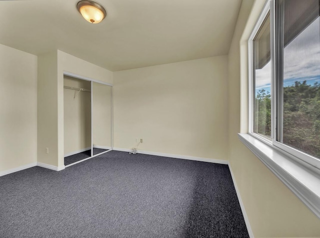 94-1727 Kaulua St, Naalehu, HI 96772 - unfurnished bedroom with dark colored carpet, baseboards, and a closet