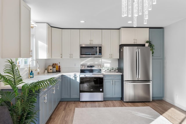 16-2143 Uilani Dr, Pahoa, HI 96778 - kitchen featuring appliances with stainless steel finishes, light countertops, a sink, light wood finished floors, and recessed lighting