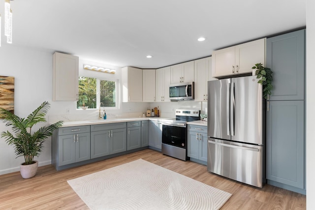 16-2143 Uilani Dr, Pahoa, HI 96778 - kitchen featuring stainless steel appliances, a sink, light countertops, light wood-type flooring, and recessed lighting