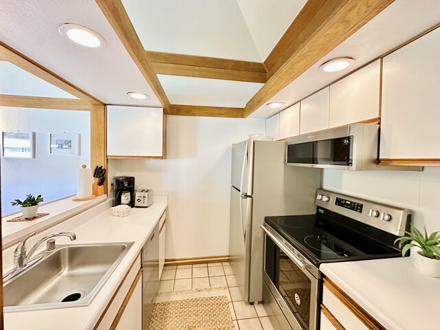 2253 Poipu Rd Unit 446, Koloa, HI 96756 - kitchen with appliances with stainless steel finishes, white cabinetry, a sink, light countertops, and light tile patterned floors