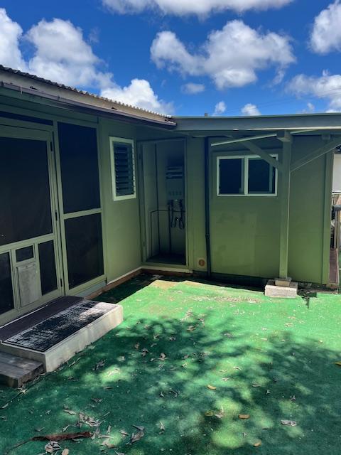 470 Hoopuni St, Hilo, HI 96720 - rear view of property with a lawn and a metal roof