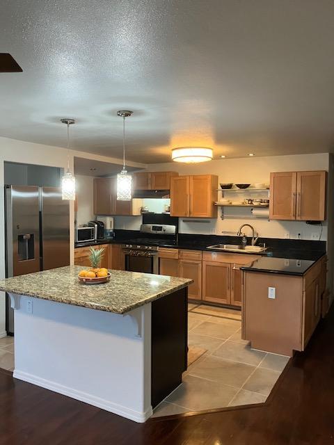 470 Hoopuni St, Hilo, HI 96720 - kitchen featuring stainless steel appliances, a kitchen island, open shelves, dark stone countertops, and pendant lighting