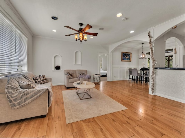 16-2069 Leilani Dr, Pahoa, HI 96778 - living room featuring arched walkways, a ceiling fan, light wood-style flooring, crown molding, and a wainscoted wall