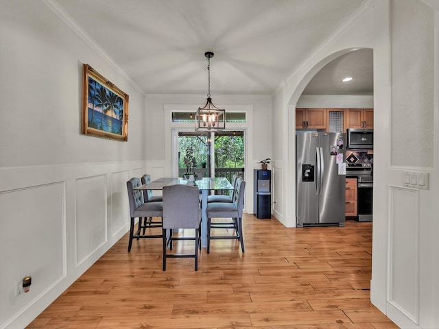 16-2069 Leilani Dr, Pahoa, HI 96778 - dining space with arched walkways, crown molding, light wood-style flooring, a decorative wall, and a wainscoted wall