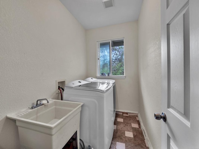 16-2069 Leilani Dr, Pahoa, HI 96778 - laundry room with independent washer and dryer, baseboards, a textured wall, and stone finish flooring
