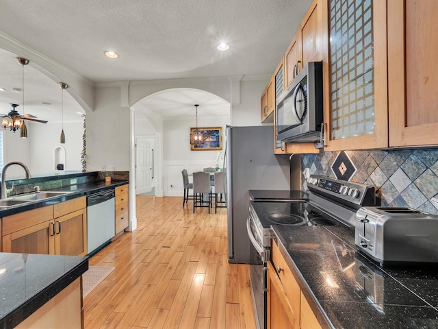 16-2069 Leilani Dr, Pahoa, HI 96778 - kitchen with appliances with stainless steel finishes, a sink, arched walkways, ceiling fan, and tasteful backsplash