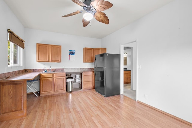 73-4571 Kukuki St Unit A, Kailua-Kona, HI 96740 - kitchen with freestanding refrigerator, light wood-style floors, ceiling fan, light countertops, and brown cabinets