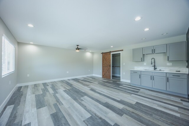 15-1674 24th Ave, Keaau, HI 96749 - unfurnished living room featuring a sink, a barn door, recessed lighting, ceiling fan, and light wood finished floors