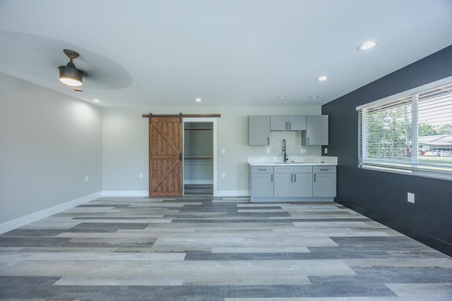 15-1674 24th Ave, Keaau, HI 96749 - kitchen featuring a barn door, gray cabinetry, light wood-style floors, recessed lighting, and a sink