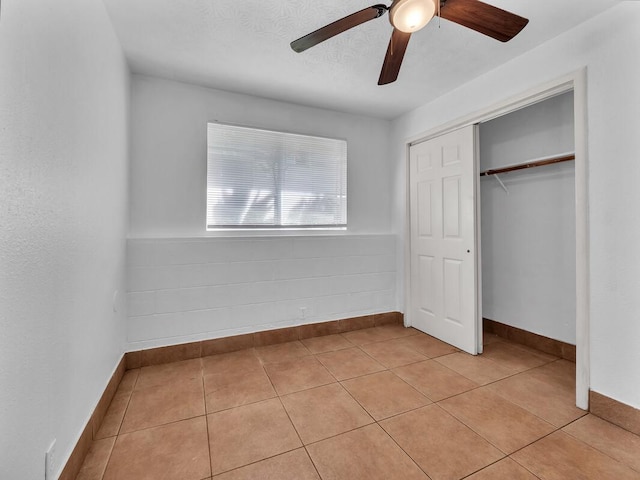 74-5156 Kialoa Pl, Kailua-Kona, HI 96740 - unfurnished bedroom with baseboards, a closet, a ceiling fan, and light tile patterned floors