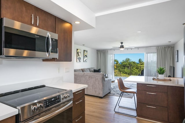 78-7070 Alii Dr Unit B202, Kailua-Kona, HI 96740 - kitchen featuring appliances with stainless steel finishes, light countertops, light wood-style flooring, dark brown cabinetry, and recessed lighting