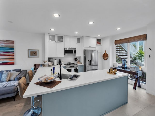 75-6009 Alii Dr Unit H2, Kailua-Kona, HI 96740 - kitchen featuring appliances with stainless steel finishes, a peninsula, a sink, light countertops, and recessed lighting