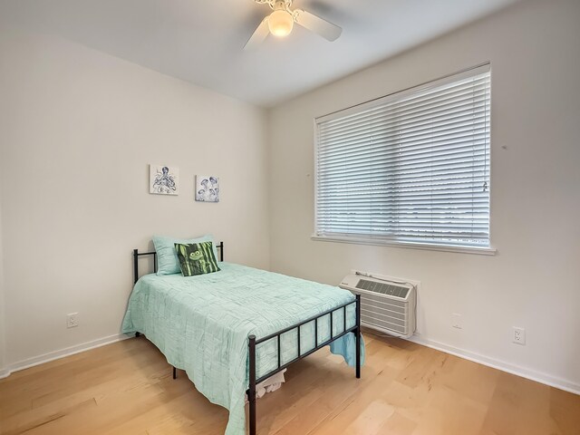 75-346 Hualalai Rd Unit B202, Kailua-Kona, HI 96740 - bedroom with light wood finished floors, a wall mounted air conditioner, and a ceiling fan