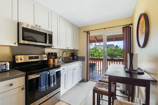 4461 Kamoa Rd Unit B22, Kapaa, HI 96746 - kitchen featuring appliances with stainless steel finishes, a sink, light wood-style floors, and white cabinets