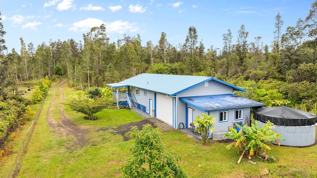 11-3458 Lehua St, Mountain View, HI 96771 - rear view of house with a yard, metal roof, a forest view, and driveway