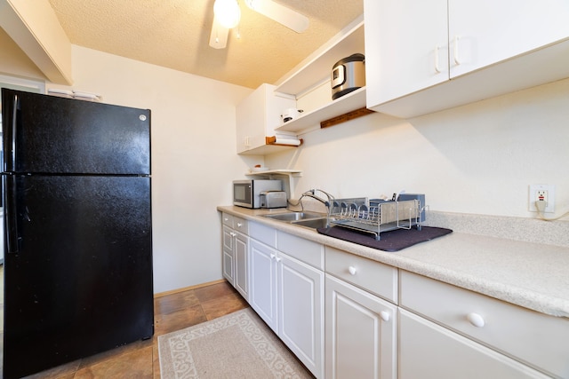 73-4327 Oneone St, Kailua-Kona, HI 96740 - kitchen with freestanding refrigerator, white cabinets, stainless steel microwave, light countertops, and a textured ceiling