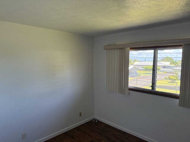 1572 Kaupili Pl, Hilo, HI 96720 - unfurnished room featuring dark wood finished floors, baseboards, and a textured ceiling