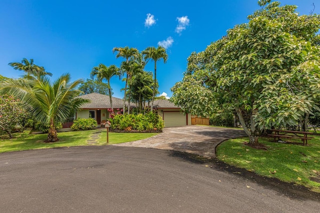 4030 Pauahi Pl, Princeville, HI 96722 - view of front of property featuring driveway, an attached garage, and a front yard