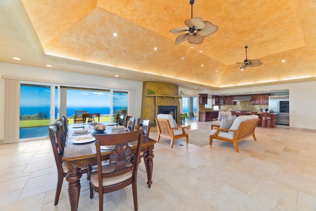 73-4558 Kukuki St, Kailua-Kona, HI 96740 - dining space with a tray ceiling, stone tile floors, ceiling fan, recessed lighting, and a fireplace
