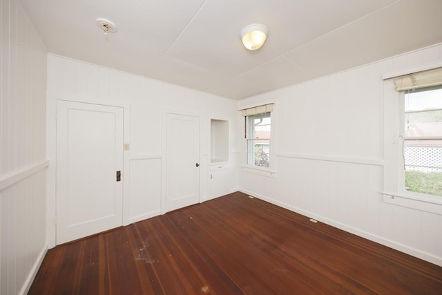 1969-A Kilauea Ave, Hilo, HI 96720 - unfurnished bedroom featuring dark wood-style floors, a decorative wall, and a closet