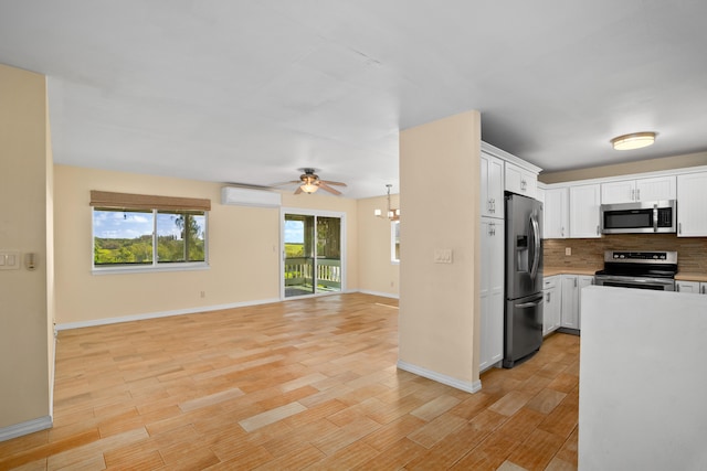 5372 Kumole St, Kapaa, HI 96746 - kitchen with appliances with stainless steel finishes, a wall unit AC, open floor plan, light countertops, and tasteful backsplash
