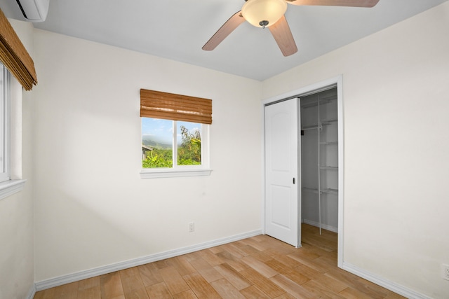 5372 Kumole St, Kapaa, HI 96746 - unfurnished bedroom featuring a closet, an AC wall unit, light wood-style floors, and baseboards