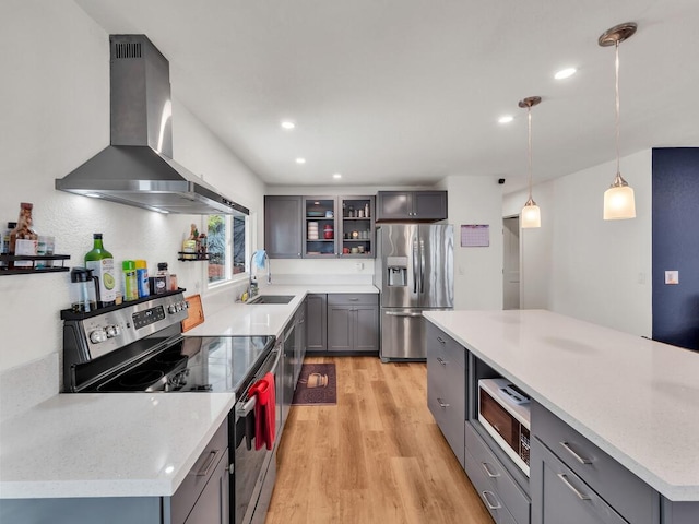 28-2855 Onomea Pl, Pepeekeo, HI 96783 - kitchen with appliances with stainless steel finishes, wall chimney range hood, light wood-style flooring, gray cabinetry, and recessed lighting