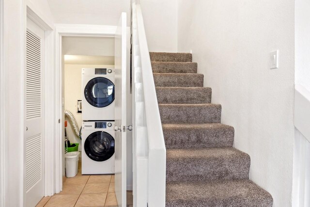 1565 Pee Rd Unit 221, Koloa, HI 96756 - laundry area featuring stacked washing machine and dryer and light tile patterned floors