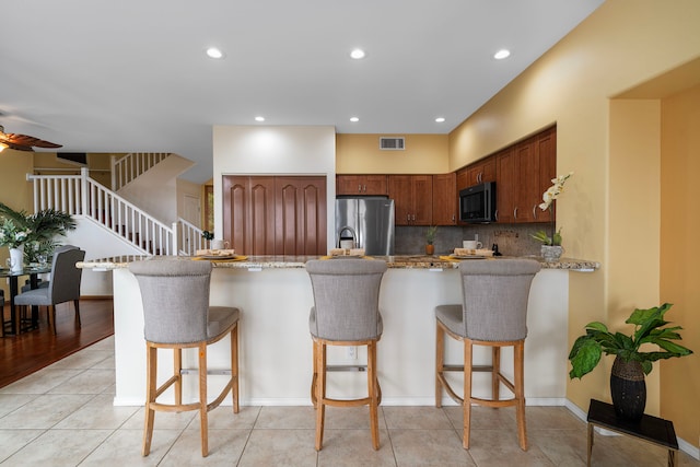 75-6060 Kuakini Hwy Unit B1, Kailua-Kona, HI 96740 - kitchen featuring black microwave, freestanding refrigerator, a kitchen bar, recessed lighting, and backsplash