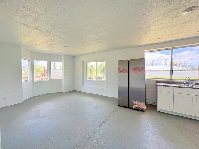 16-2122 Ginger Ln, Pahoa, HI 96778 - kitchen featuring freestanding refrigerator, a sink, a textured ceiling, white cabinets, and dark countertops