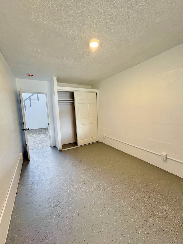 16-2122 Ginger Ln, Pahoa, HI 96778 - unfurnished bedroom with a textured ceiling, light speckled floor, baseboards, and a closet