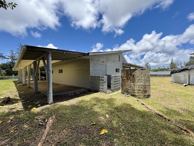 16-2122 Ginger Ln, Pahoa, HI 96778 - view of side of property featuring a patio, an attached carport, and concrete block siding
