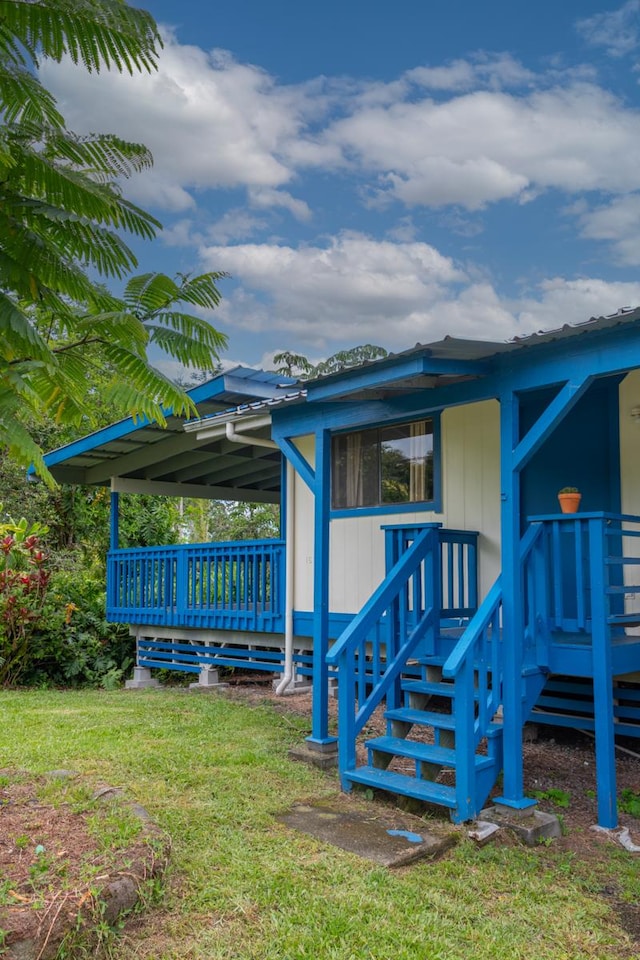 16-2103 Kuleana St, Pahoa, HI 96778 - view of side of property featuring a lawn, a deck, and a metal roof
