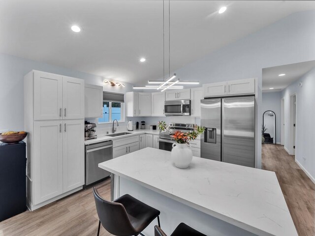 11-3073 Puolani St, Volcano, HI 96785 - kitchen with stainless steel appliances, a sink, a breakfast bar area, light stone countertops, and light wood-type flooring