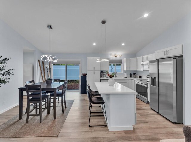 11-3073 Puolani St, Volcano, HI 96785 - kitchen with stainless steel appliances, vaulted ceiling, a kitchen island, white cabinets, and light countertops