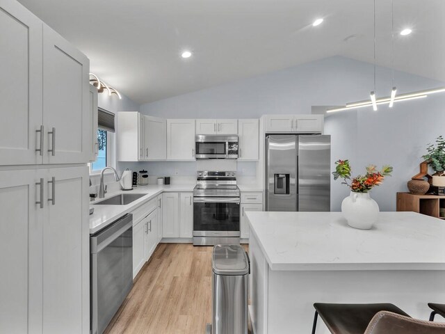 11-3073 Puolani St, Volcano, HI 96785 - kitchen featuring appliances with stainless steel finishes, a sink, vaulted ceiling, light wood-type flooring, and a breakfast bar area