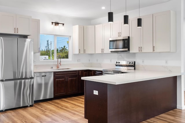 15-1770 10th Ave, Keaau, HI 96749 - kitchen with appliances with stainless steel finishes, a sink, a peninsula, light countertops, and light wood-style floors
