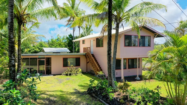 12-7040 Kaihalulu St, Pahoa, HI 96778 - rear view of house featuring a yard, a sunroom, and stairs