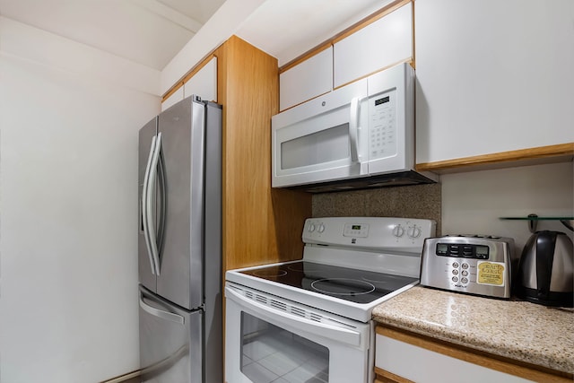 2253 Poipu Rd Unit 230, Koloa, HI 96756 - kitchen featuring white appliances, white cabinetry, and tasteful backsplash