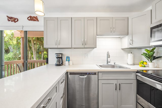 3411 Wilcox Rd Unit F 69, Lihue, HI 96766 - kitchen featuring appliances with stainless steel finishes, light countertops, backsplash, and gray cabinets