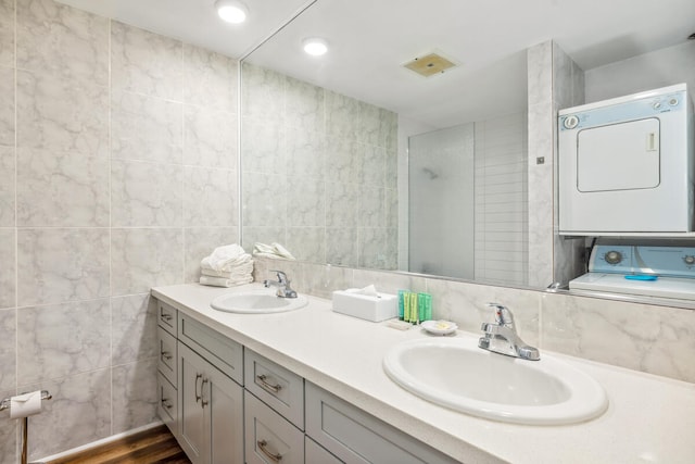 3411 Wilcox Rd Unit F 69, Lihue, HI 96766 - bathroom with estacked washer and dryer, double vanity, tile walls, and tiled shower