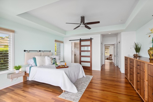 76-4391 Leilani St, Kailua-Kona, HI 96740 - bedroom with a barn door, a raised ceiling, wood finished floors, and ceiling fan