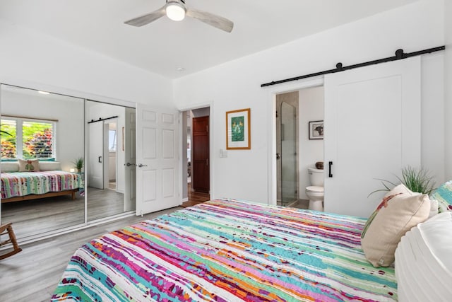 76-4391 Leilani St, Kailua-Kona, HI 96740 - bedroom with a barn door, a closet, wood finished floors, and ensuite bath