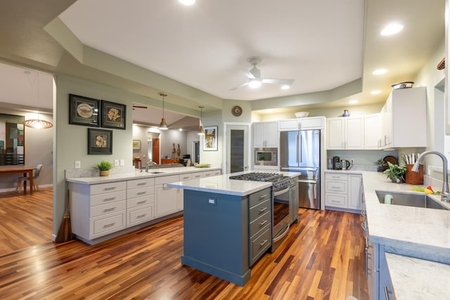 76-4391 Leilani St, Kailua-Kona, HI 96740 - kitchen featuring appliances with stainless steel finishes, wood finished floors, white cabinetry, a ceiling fan, and a kitchen island